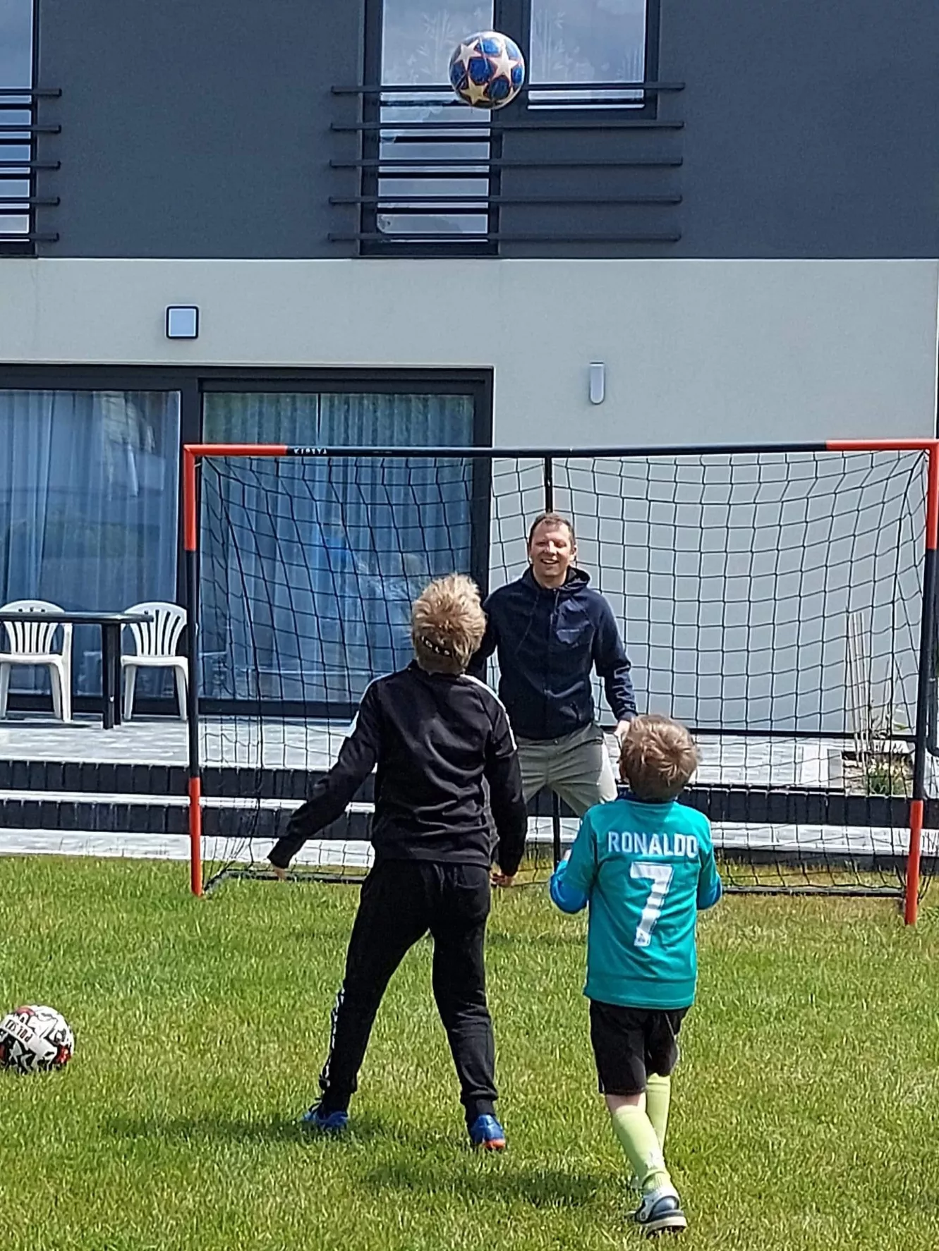 Paweł Filarczyk grający w piłkę nożną z dziećmi.