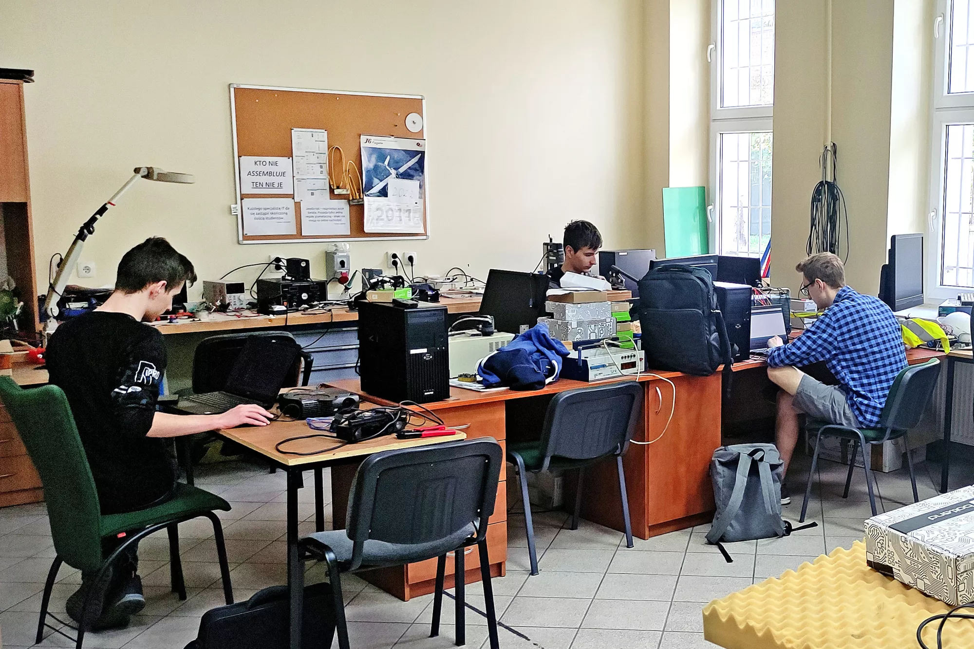 Studenci z SKN Main pracują w sali komputerowej.