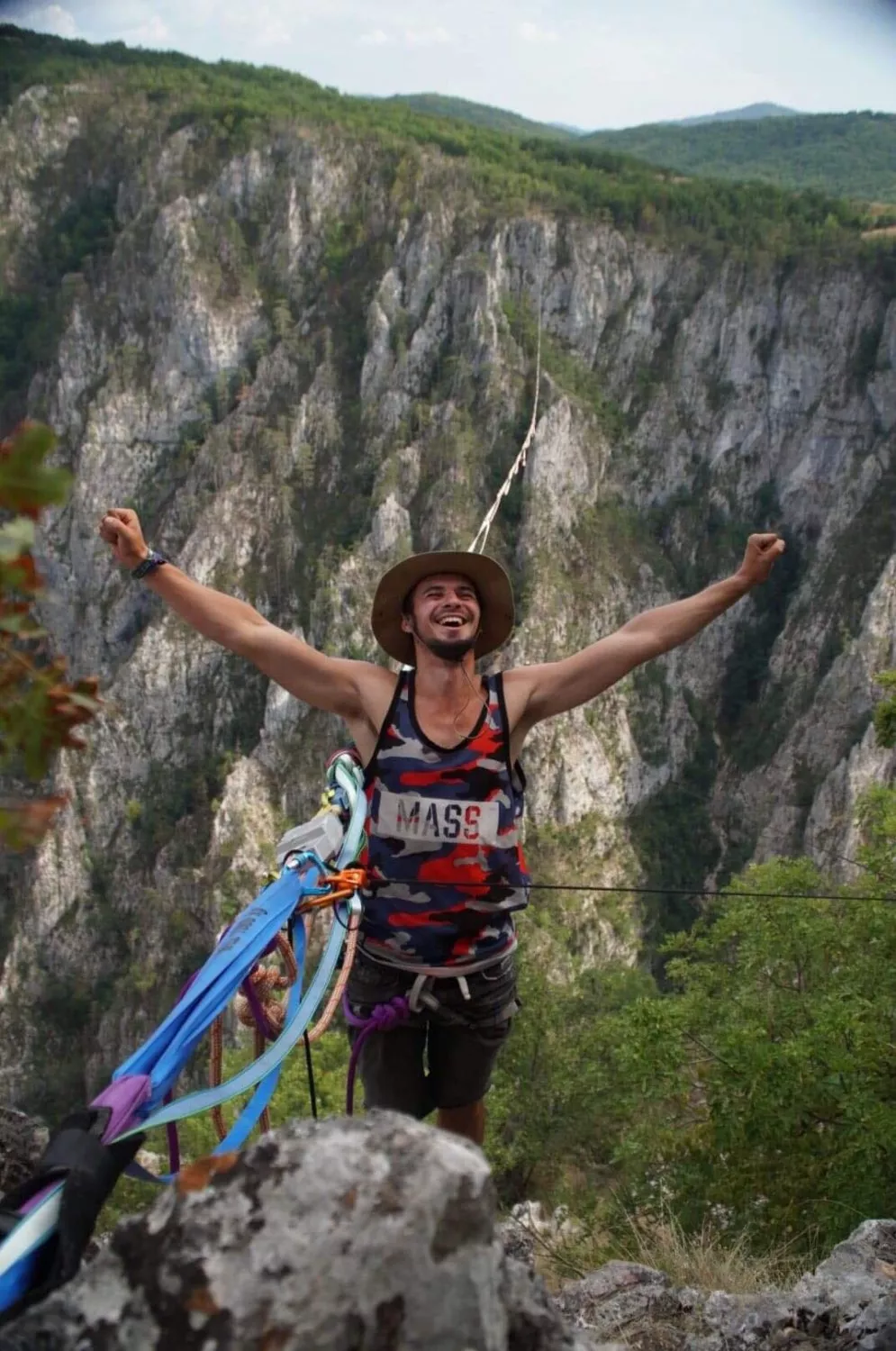 Student w sportowym stroju spaceruje po linie w górach.