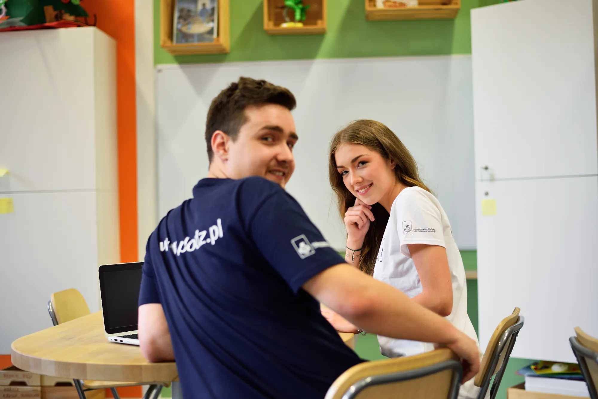 Studenci rozmawiają przy stole.