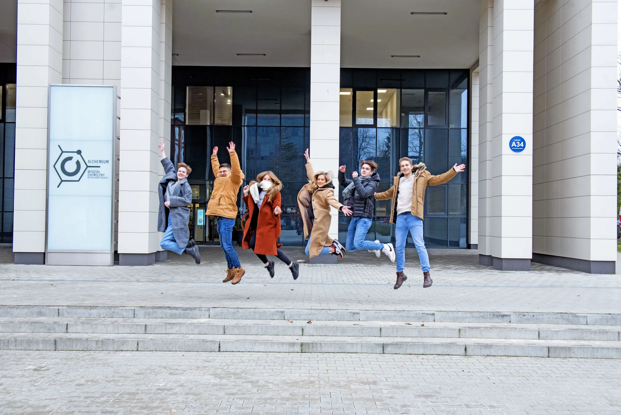 Studenci skaczą ze schodów.