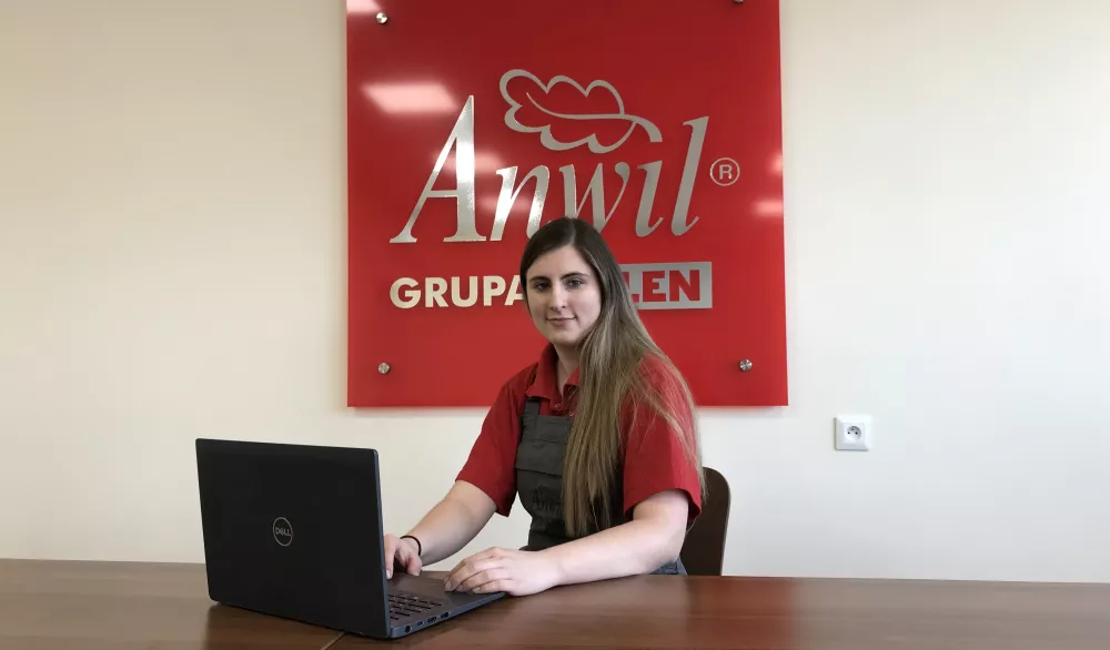 Kobieta siedzi przy laptopie w firmie.