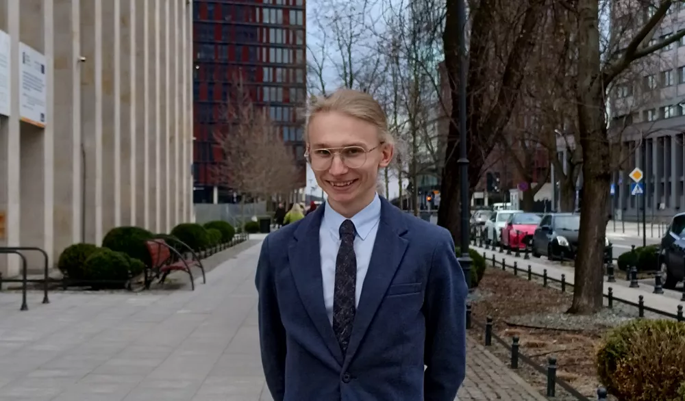 Mężczyzna stoi przed budynkiem.