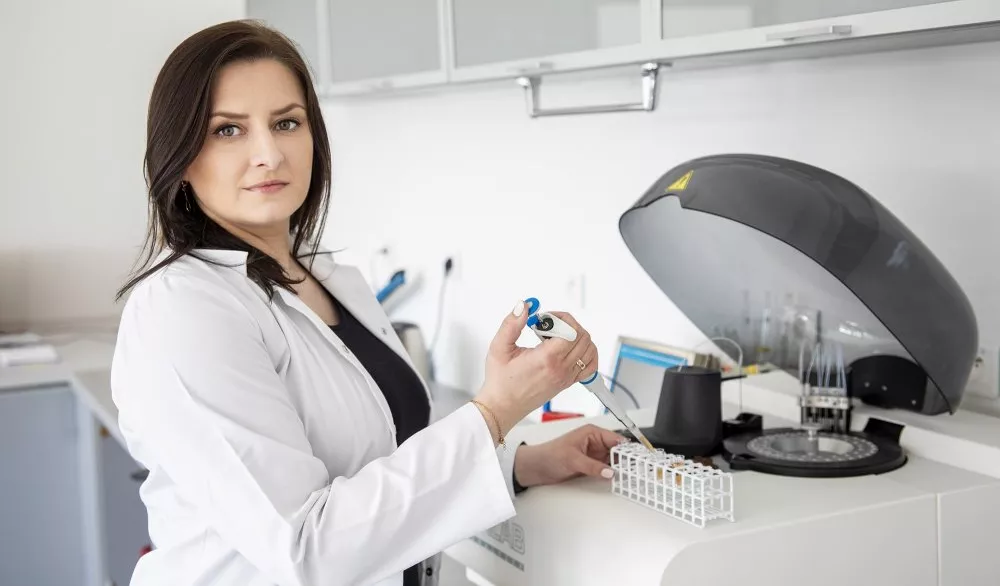 Kobieta przy urządzeniu w laboratorium.