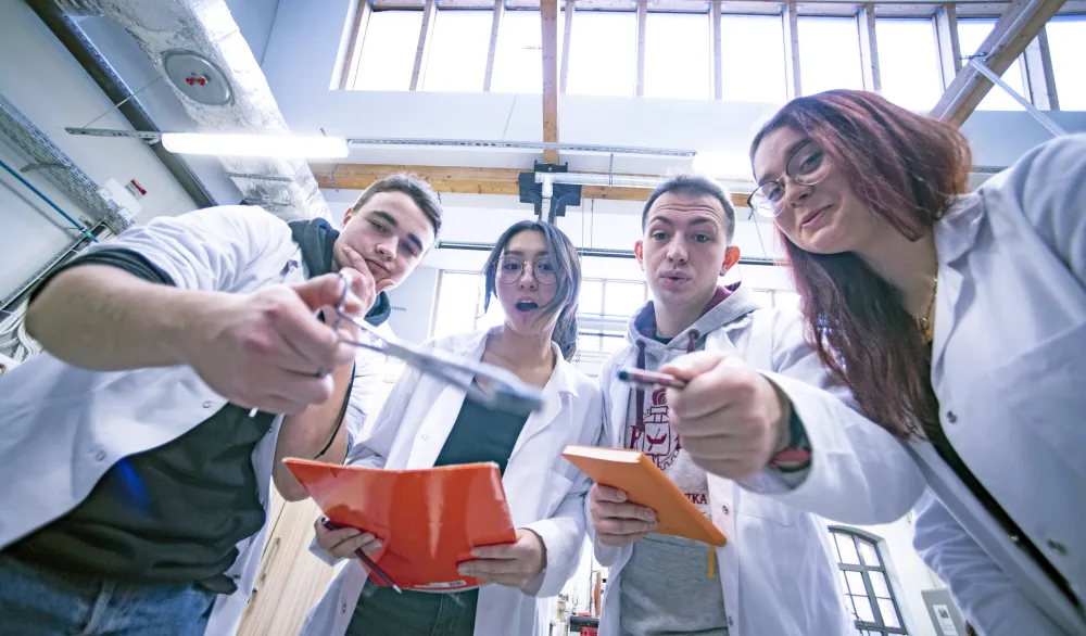 Studenci pokazują narzędzia pracy w pracowni.