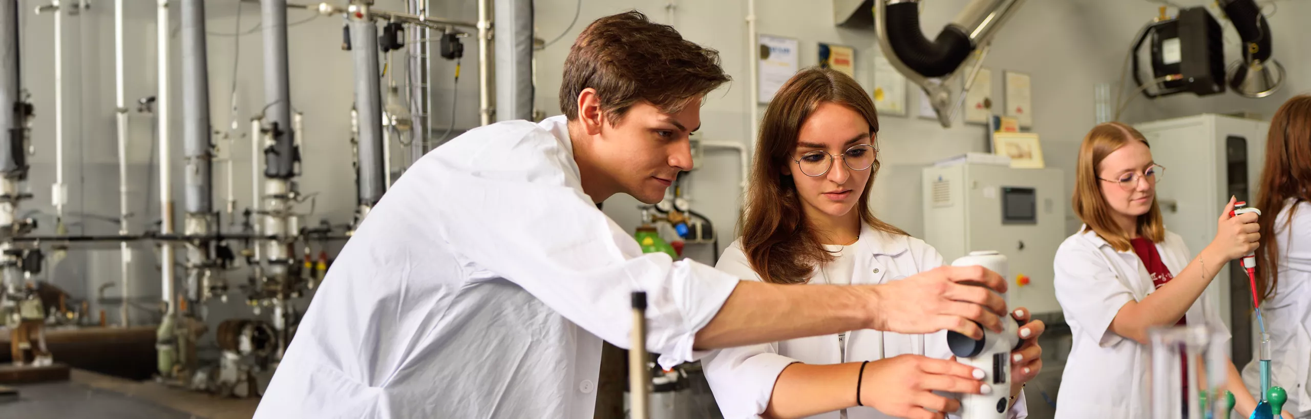 Studenci prowadzą eksperymenty w laboratorium chemicznym.
